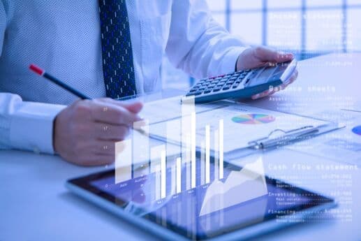 Pessoa analisando gráficos financeiros com calculadora