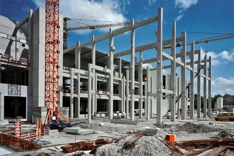 Construção com estruturas de concreto e guindastes