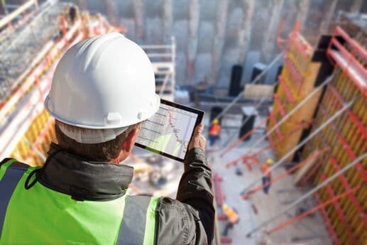 Profissional de construção usando tablet no canteiro de obras