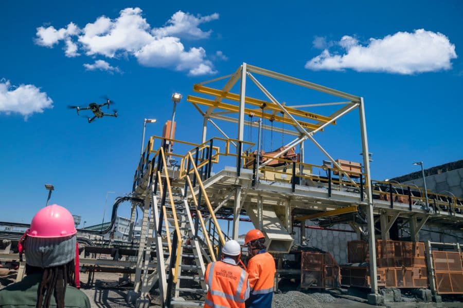 Trabalhadores observando drone em obra industrial