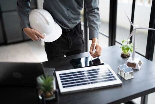 Profissional ajustando painel solar em escritório.