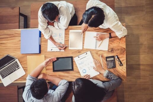 Reunião de equipe com documentos e tecnologia